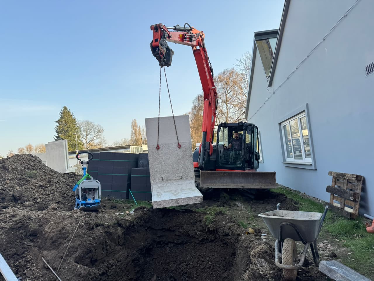 Minibagger hebt ein Fundamentelement bei Baggerarbeiten in Bielefeld