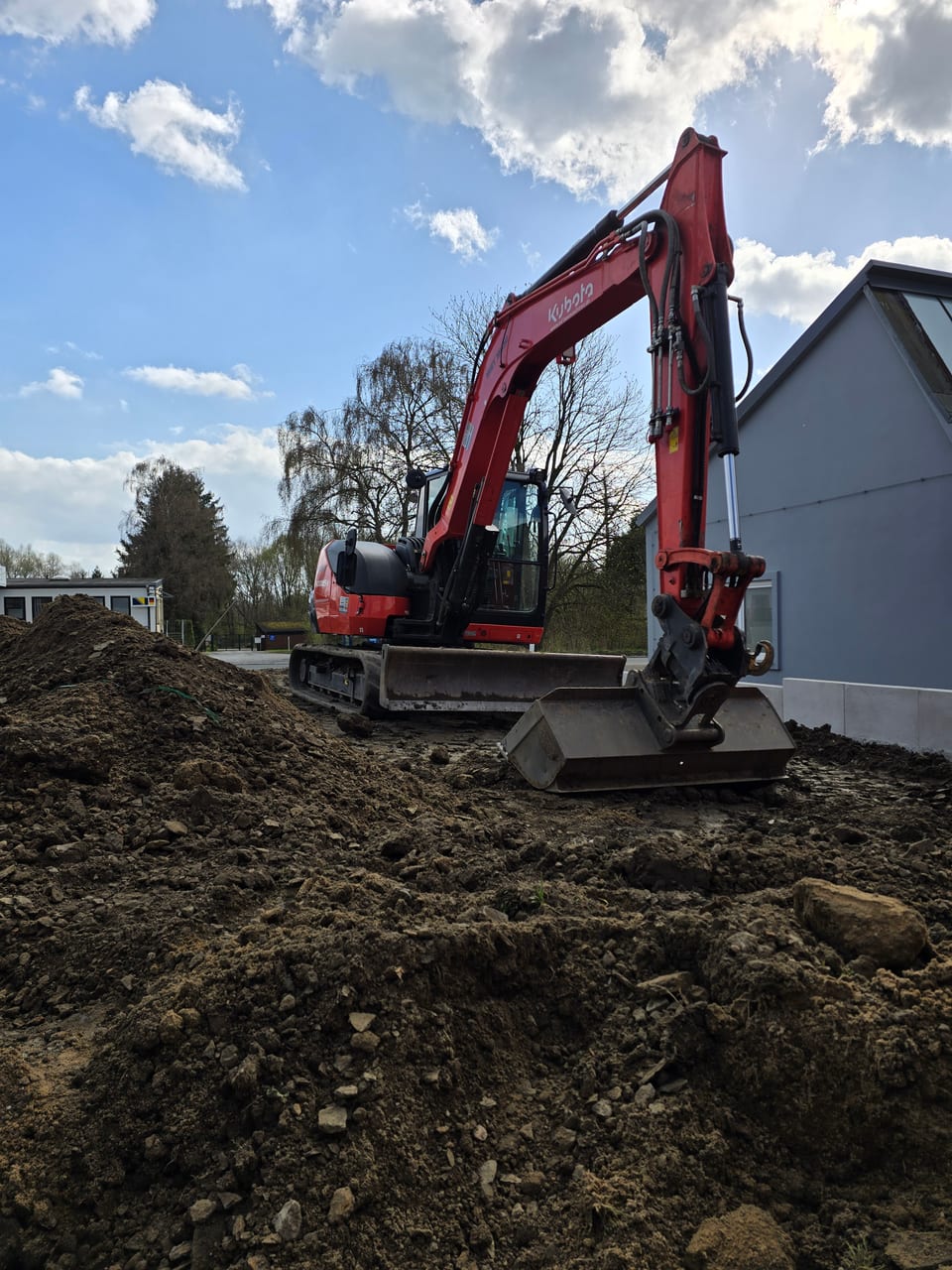 Minibagger bei Erdarbeiten an der Hauswand in Bielefeld