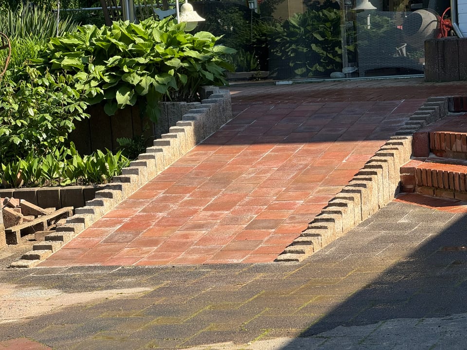 Pflasterrampe in Bielefeld mit 20x20 Pflastersteinen und Palisaden aus Muschelkalk