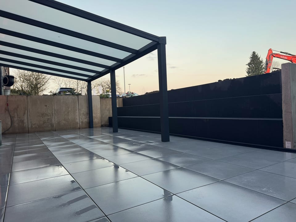 Terrasse mit Glasdach und Sichtschutzwand in der Abenddämmerung in Bielefeld