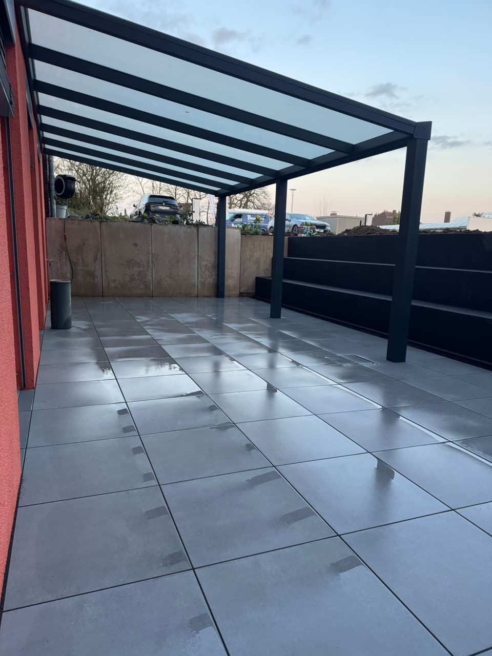 Terrassenbau in Bielefeld - fertige Terrasse mit Großformatplatten unter der Pergola