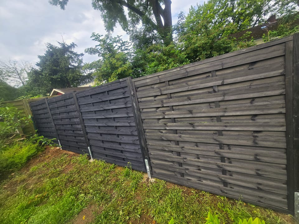 Zaunbau in Bielefeld - Sichtschutzzaun aus dunkel lasierten Holzlamellen
